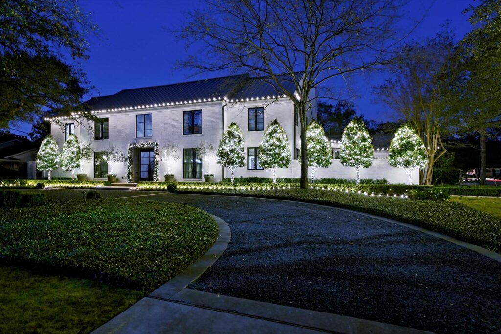 home with front trees decorated with christmas lights